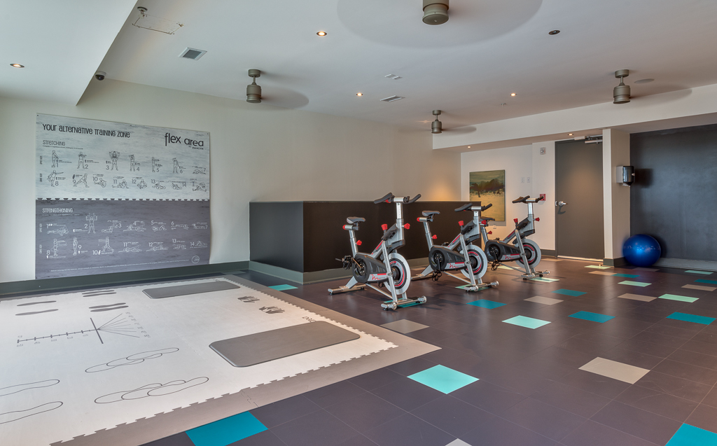 Indoor gym area with yoga training mats, cardio machines, and exercise balls
