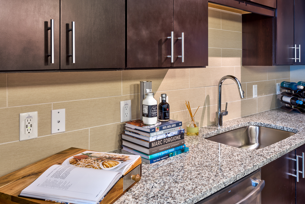 Kitchen area with granite countertops, wood-style cabinets, and cooking books
