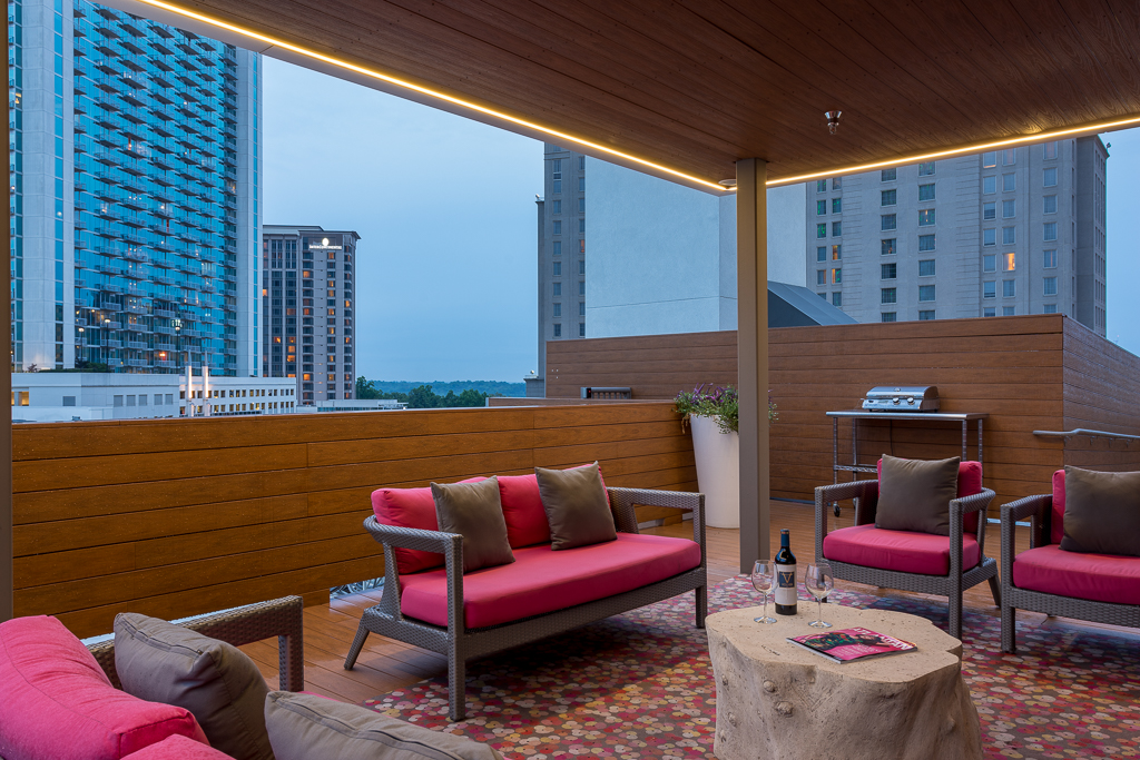 Clubhouse seating with couches, chairs, grilling stations, and open access to city view