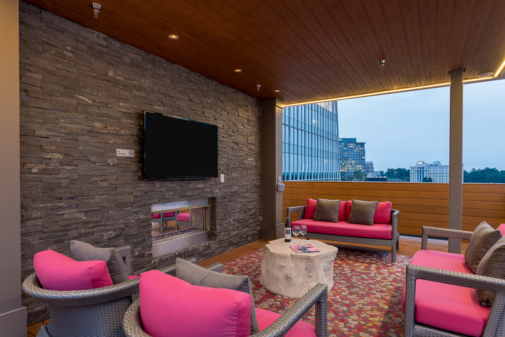 Clubhouse seating with couches, chairs, fire pit, TV, and open access to city view