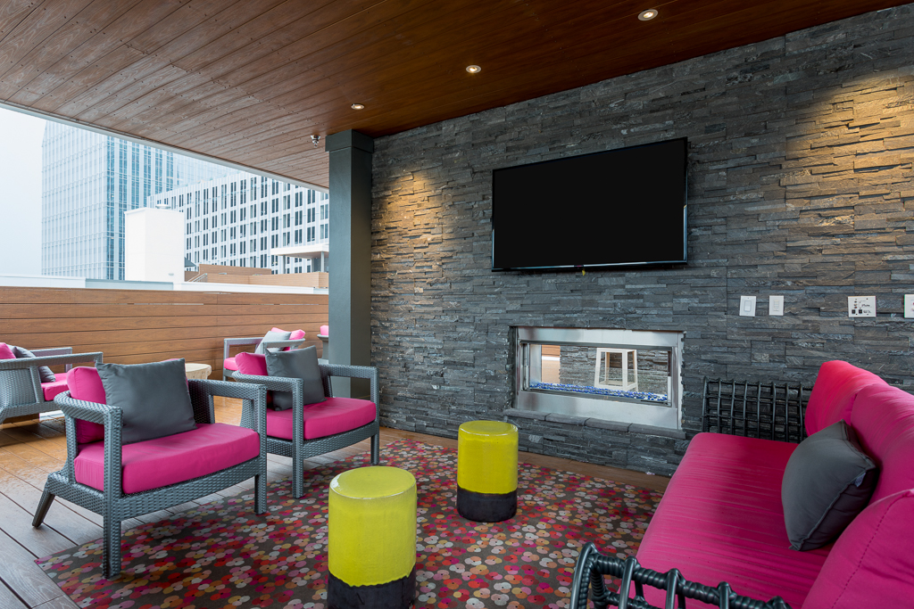 Clubhouse seating with couches, chairs, fire pit, TV, and open access to city view